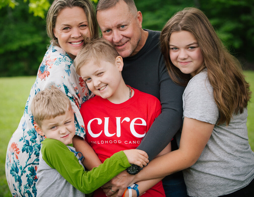 CURE Flags captain section image a family of four hugging a child wearing a CURE tshirt