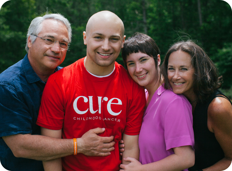 Family in CURE shirts smiling and embracing outdoors